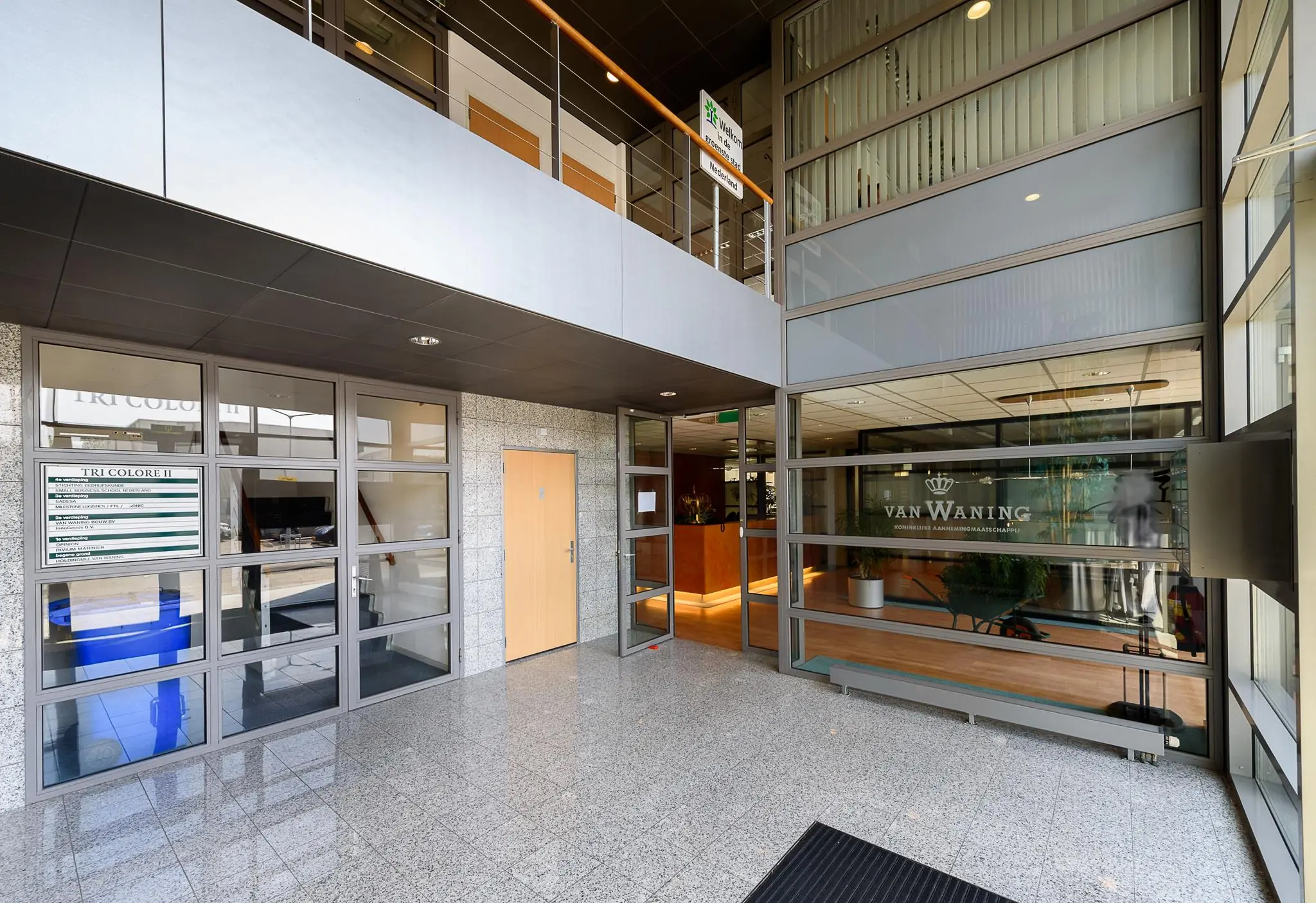 Entreehal van een bedrijfsverzamelgebouw aan de Rivium 2e Straat met kantoren van onder andere Van Waning en Tri Colore II.